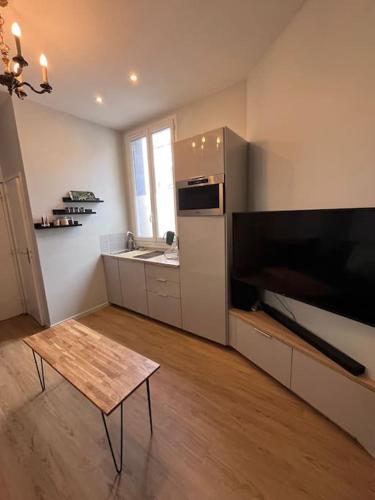 Il comprend une cuisine avec une table et une télévision à grand écran. dans l'établissement Studio Gare, à Rouen