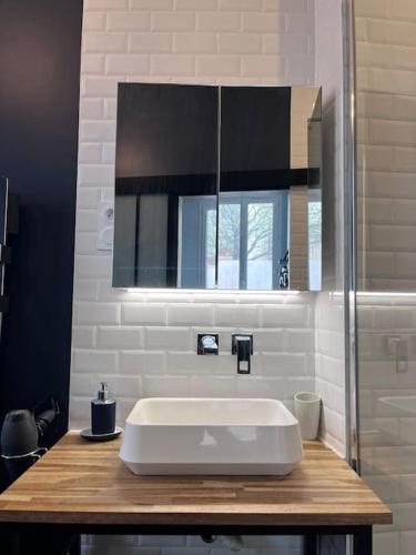 une salle de bain avec un lavabo blanc et un miroir dans l'établissement Studio Gare, à Rouen