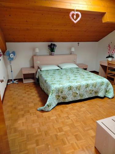 - une chambre avec un grand lit et du parquet dans l'établissement Belvedere, à Levico Terme