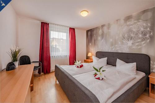 una camera da letto con un letto con due fiori sopra di Waldsiedlung Waldhaus App 4.2 a Korswandt