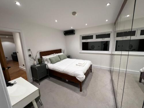 a bedroom with a bed and a glass shower at Hassocks House - Modern Detached 2 Bedroom House in Streatham in Streatham Vale