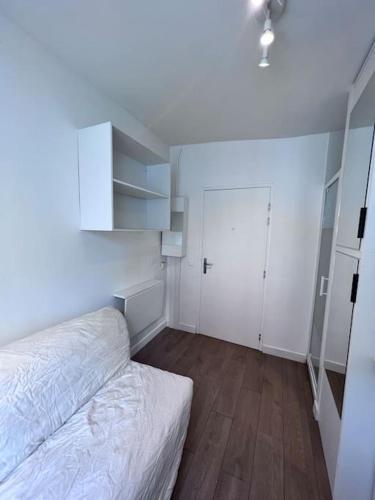 une chambre blanche avec un lit et un placard dans l'établissement Paris Montmartre - Studio équipé - 1P, à Paris