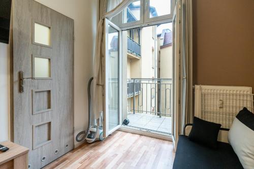 um quarto com uma porta que leva a uma varanda em Main Square Teatralna - 2 room apartment with balcony - self-in - coffee and tea em Katowice