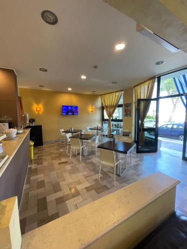 a restaurant with tables and chairs in a room at Hotel Promenade in Porto SantʼElpidio