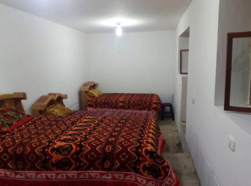 Homestay Ausangate في Tinke: غرفة نوم بسريرين في غرفة