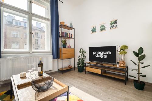 een woonkamer met een tv en een tafel bij Cozy apartment near parks in Žižkov by Prague Days in Praag