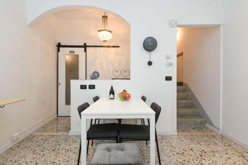 een eetkamer met een witte tafel en stoelen bij Casa Daniela in Desenzano del Garda