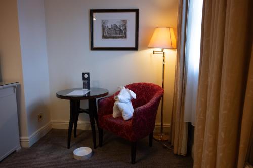 a teddy bear sitting in a chair next to a table at Park House Hotel in Shifnal