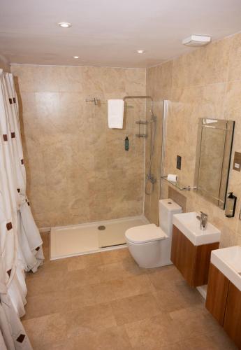 a bathroom with a toilet and a shower and a sink at Park House Hotel in Shifnal