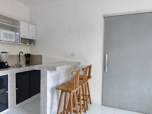 雅帕拉廷加的住宿－Apartamento inteligente，厨房在柜台上设有两张木凳