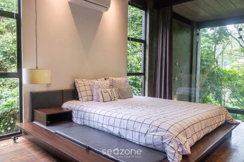 a bed in a room with a large window at Casa moderna e equipada em Petrópolis-RJ RSS175 in Petrópolis