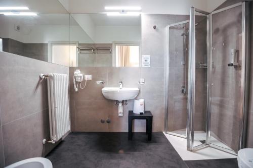 W łazience znajduje się umywalka i prysznic. w obiekcie Hotel Arilica w mieście Peschiera del Garda