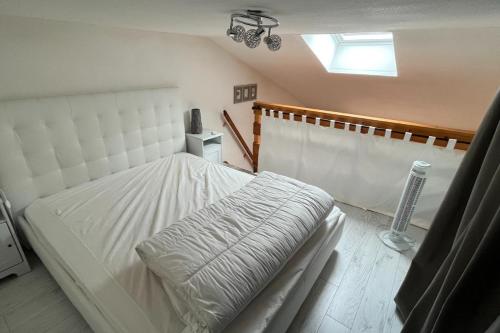 une chambre avec un lit blanc et une fenêtre dans l'établissement Maison de vacances plage des demoiselles St Jean, à Saint-Hilaire-de-Riez