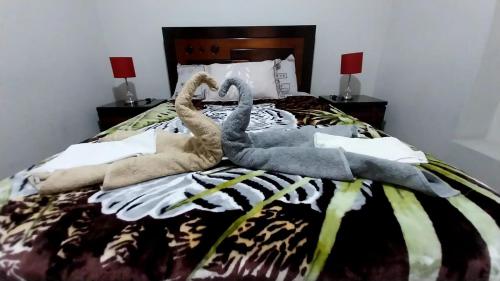 2 cigni fatti di asciugamani su un letto di Apartamentos Gutierrez a Lima