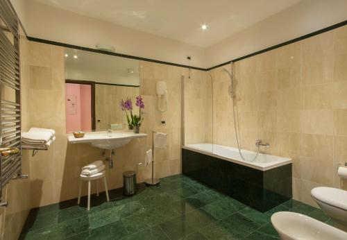 a bathroom with a tub and a sink at Hotel La Pergola in Rome