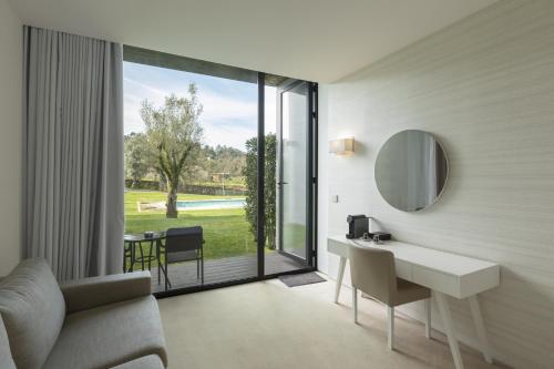 a hotel room with a desk and a large window at Tempus Hotel & Spa in Ponte da Barca