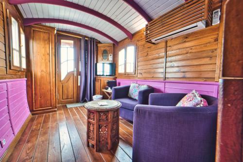 a train room with purple chairs and a table at Mas De Calabrun in Saintes-Maries-de-la-Mer