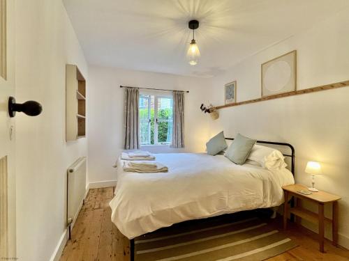 a bedroom with a bed and a window at Mafeking in Benenden - an Inspire Stays home in Benenden