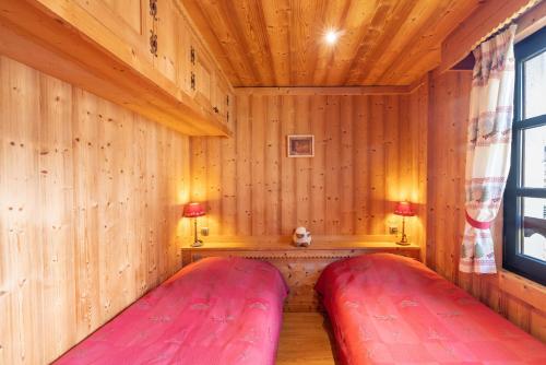 a room with two red pillows in a wooden room at Appartement les 4 As in Megève