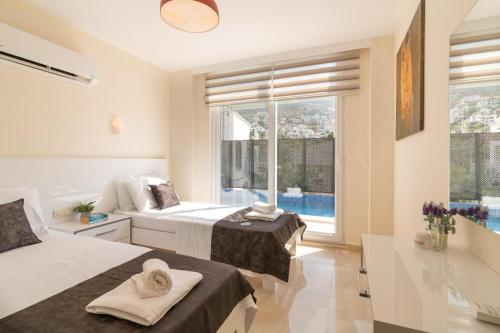 a bedroom with two beds and a large window at Pearl Apart in Kas