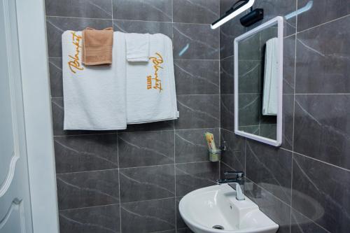 uma casa de banho com lavatório, espelho e toalhas em Blanket Suites em Kampala