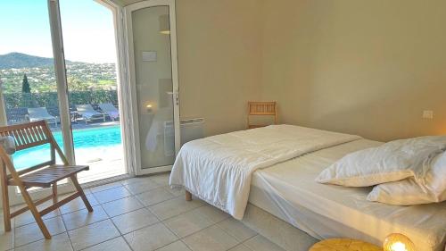 1 dormitorio con cama y vistas a la piscina en Les Geais, en Sainte-Maxime
