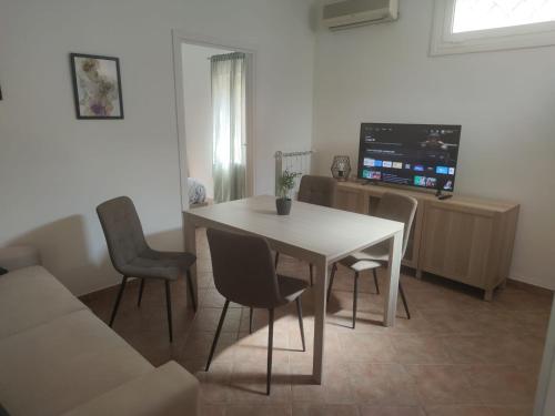 a living room with a table and chairs and a tv at La Passeggiata in Santa Marinella