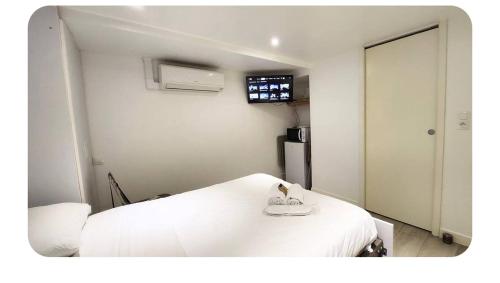 een ziekenhuiskamer met een wit bed en een koelkast bij Les Garennes in Rillieux