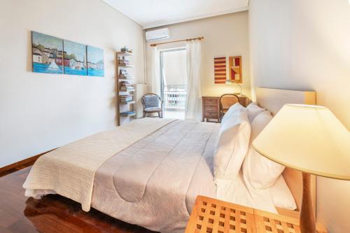 a bedroom with a large bed with a lamp at Family Apt in Glyfada-Kyprou, by Comfortbnb in Athens
