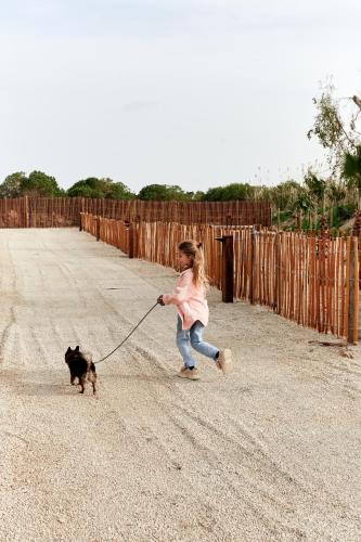 a little girl walking a dog on a leash at TAIGA Delta de l'Ebre in L'Ampolla