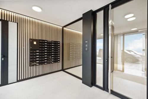 bodega con paredes blancas y negras y puertas de cristal en Apartment with frontal sea view in Knokke, en Knokke-Heist