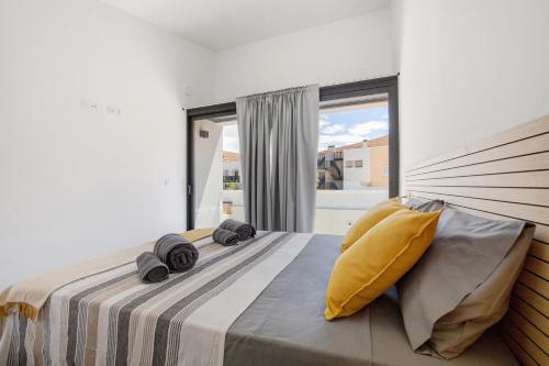 ein Schlafzimmer mit einem großen Bett mit gelben Kissen in der Unterkunft Las Cuestitas Relax in Pájara