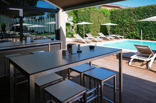 a patio with a table and chairs next to a swimming pool at Hotel Palazzo del Garda & Spa in Desenzano del Garda