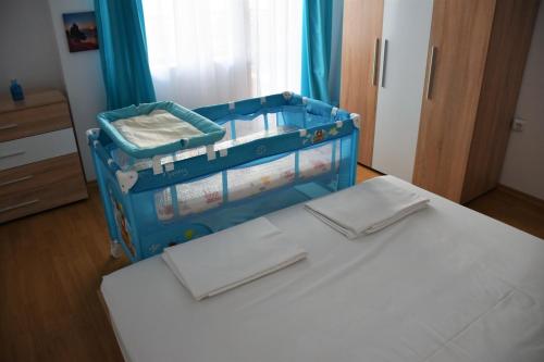 una valigia blu seduta su un letto in una stanza di Aglaya 2 - Pomorie Bay a Pomorie