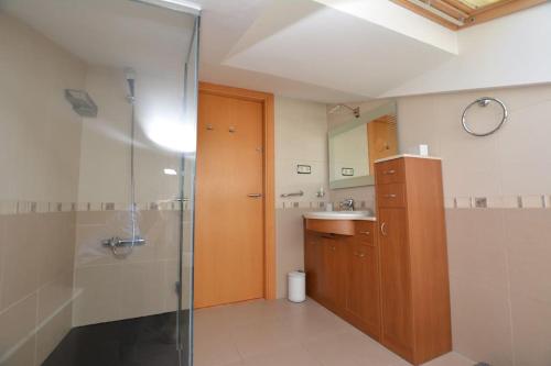 a bathroom with a glass shower and a sink at Private and charming apartment in front of the sea in Altafulla