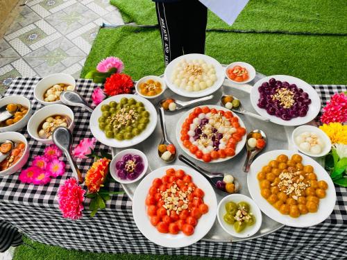 a table with plates of food and bowls of dips at Wooden floor house Ngọc trinh Homestay in Bản Qua