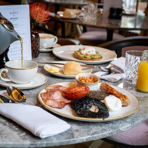 a table with plates of food and a cup of coffee at The Scott in Edinburgh