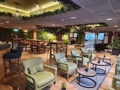 a lobby with chairs and tables and a bar at Ashorne Hill Leamington Spa in Leamington Spa