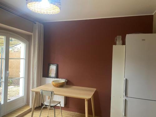 une cuisine avec une table en bois et un réfrigérateur dans l'établissement Charmante longère girondine, à Saint-Ciers-sur-Gironde