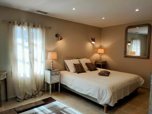 une chambre avec un grand lit et un miroir dans l'établissement Le mas de Roussillon chambre d'hôtes, à Roussillon