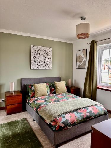 a bedroom with a bed and a window at Apartment with parking, close to the Raigmore hospital in Inverness
