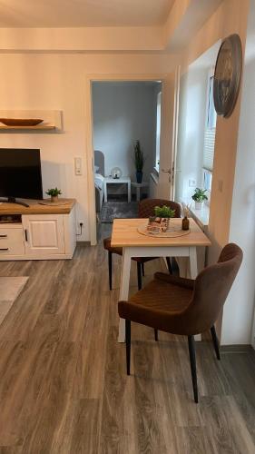 a living room with a table and chairs and a television at Sweet Sleep Apartment in Burg Stargard