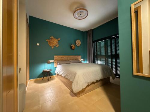 a bedroom with a bed and a green wall at Casa Stelios Haciënda del Alamo in Escobar