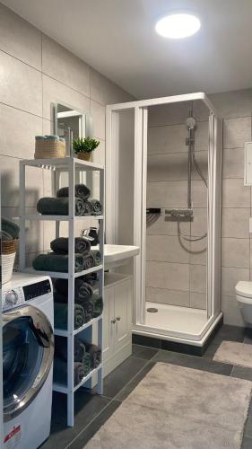 a bathroom with a shower and a washing machine at Sweet Sleep Apartment in Burg Stargard