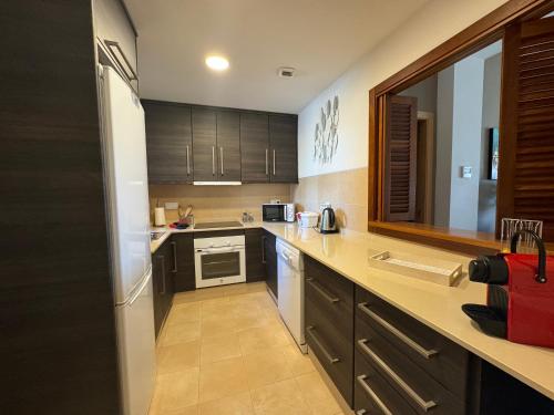 a kitchen with wooden cabinets and a counter top at Casa Stelios Haciënda del Alamo in Escobar