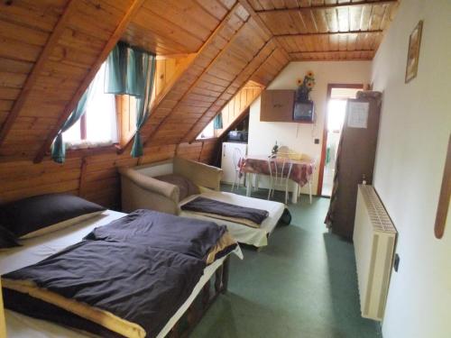 1 dormitorio con 2 camas y comedor con mesa en Gaz69 vendégház en Szilvásvárad