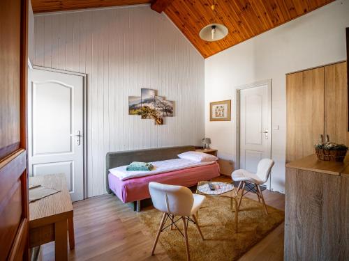 a bedroom with a bed and two chairs in it at Ubytovanie Clematis in Trenčianske Teplice