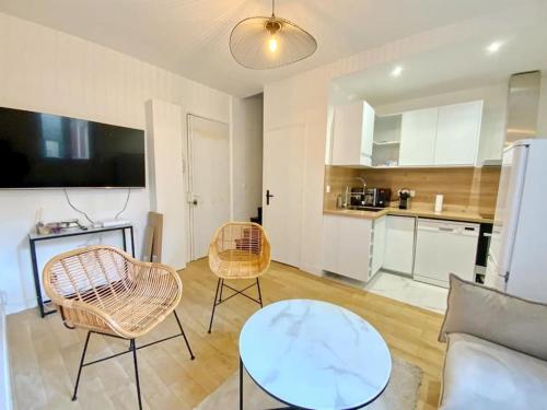 un salon avec une table et des chaises et une cuisine dans l'établissement GoodGuest-Cosy Duplex Gare D’Asnieres, à Asnières-sur-Seine