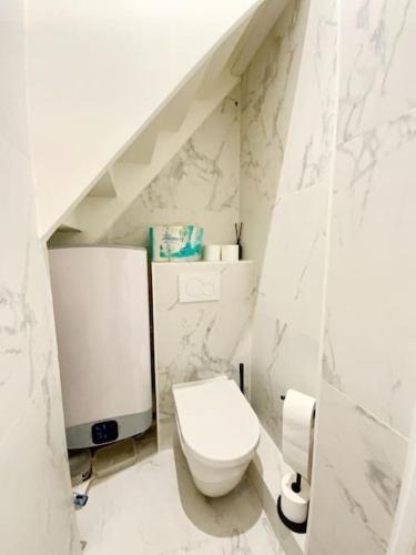 une salle de bain blanche avec des toilettes et un lavabo dans l'établissement GoodGuest-Cosy Duplex Gare D’Asnieres, à Asnières-sur-Seine