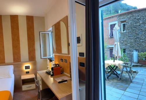 Cette chambre comprend un lit, un bureau et une fenêtre. dans l'établissement Locanda Ca Da Iride, à Riomaggiore